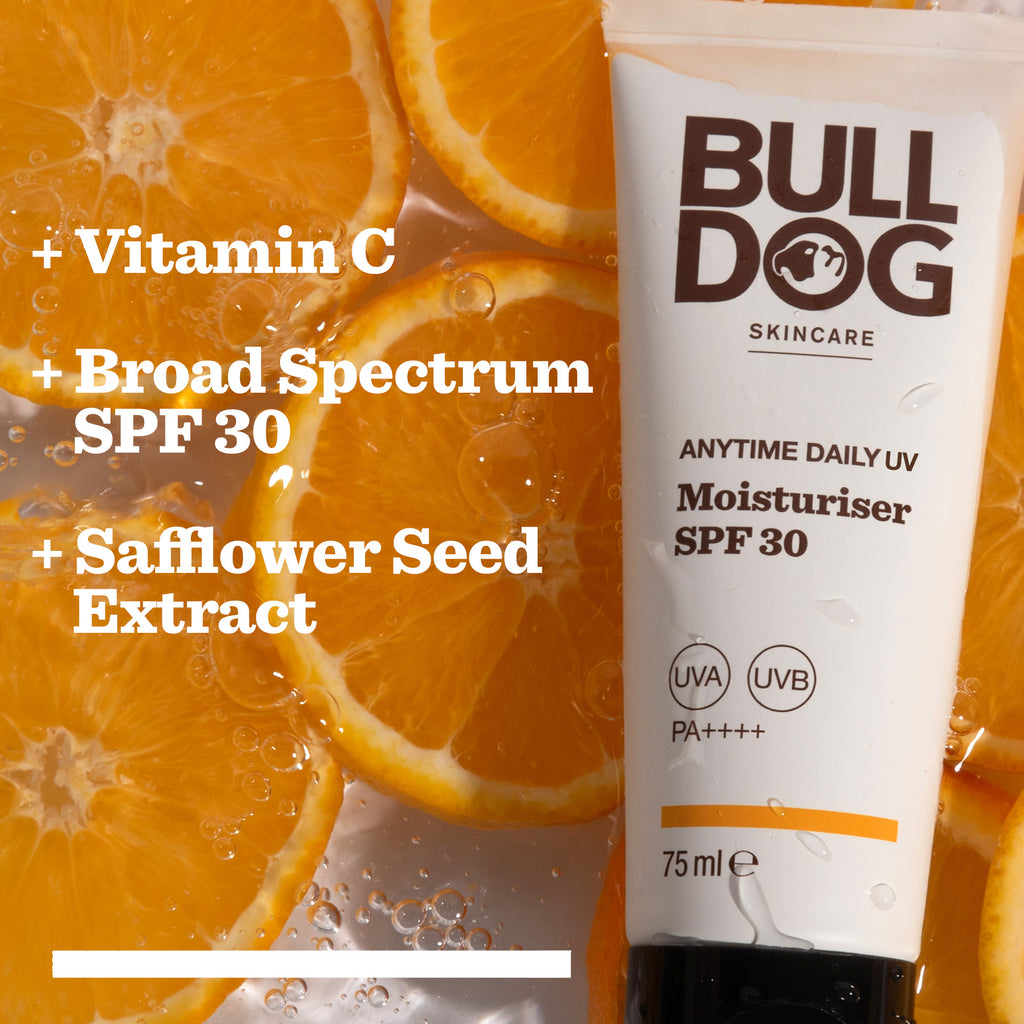 A tube of Anytime Daily Moisturiser SPF 30 rests on fresh orange slices. Text highlights its features: Vitamin C, broad-spectrum UVA/UVB protection, and Safflower Seed Extract.