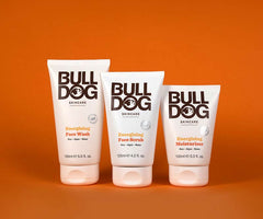 The Bulldog Energising Collection Bundle, featuring signature white packaging, is displayed upright on an orange background—perfect for enhancing your Energising Skincare or Bulldog Washbag routine.
