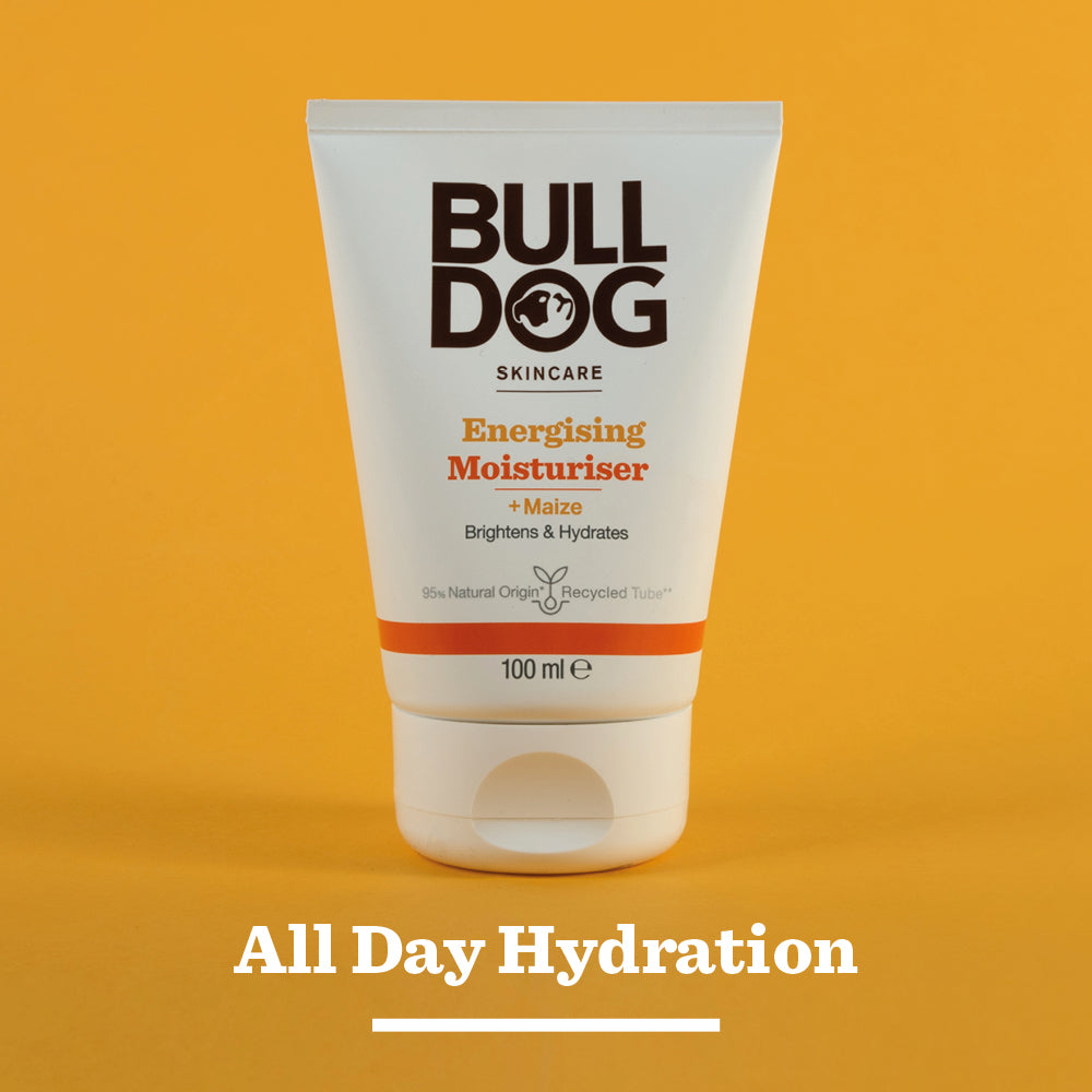 A tube of Energising Moisturiser stands upright against an orange background, with All Day Hydration below it and a focus on its natural origin ingredients.