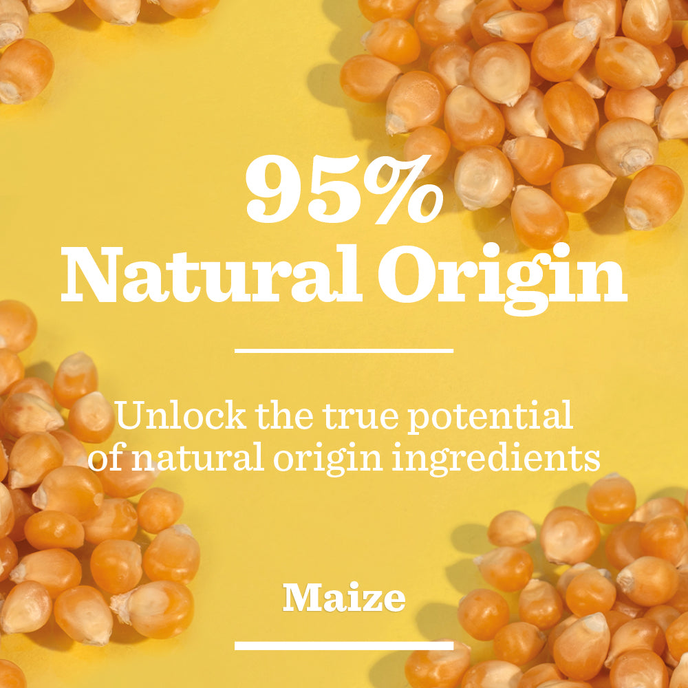 Yellow and orange maize kernels are scattered on a yellow background. Bold white text in the center reads “95% Natural Origin”, with smaller text below stating, “Unlock the true potential of brightening properties. Energising Moisturiser.”.