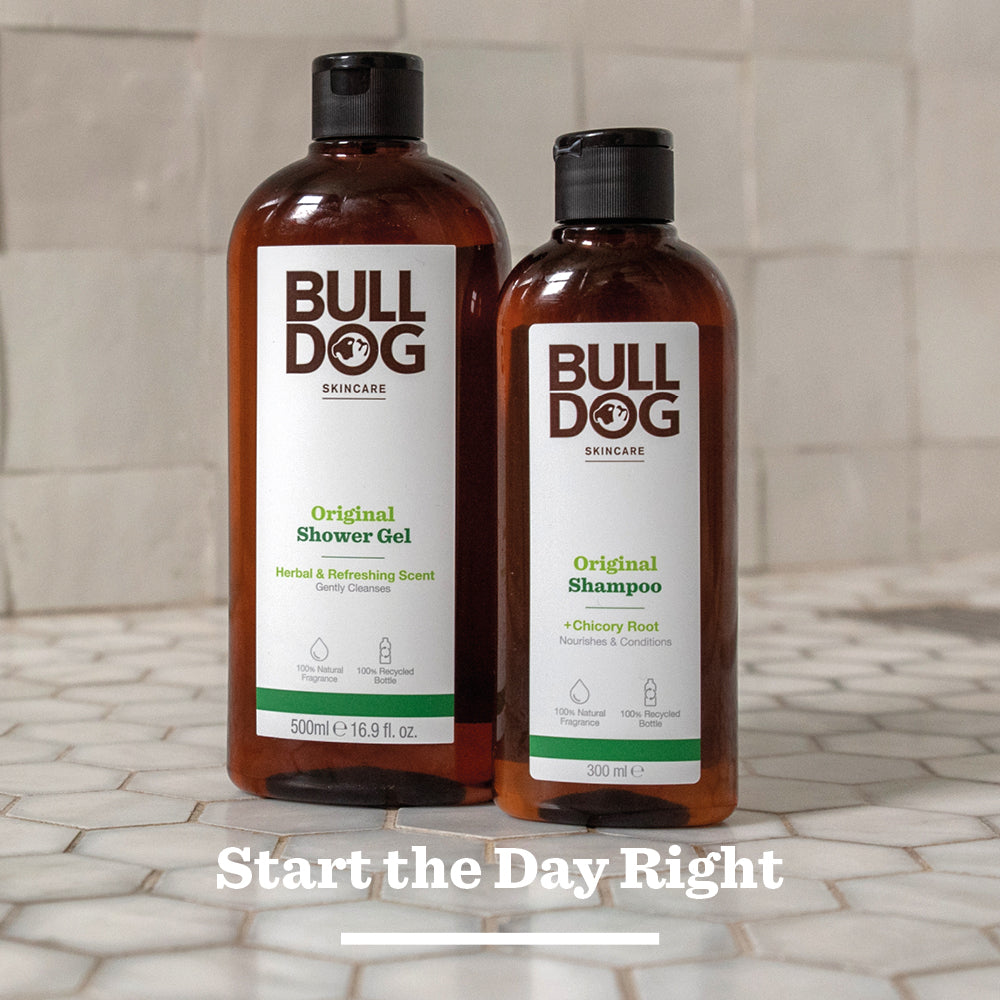 A bottle of Bulldog Skincare’s Original Shampoo stands on a tiled surface, highlighting mens hair care with natural ingredients. The text Start the Day Right is written below it.