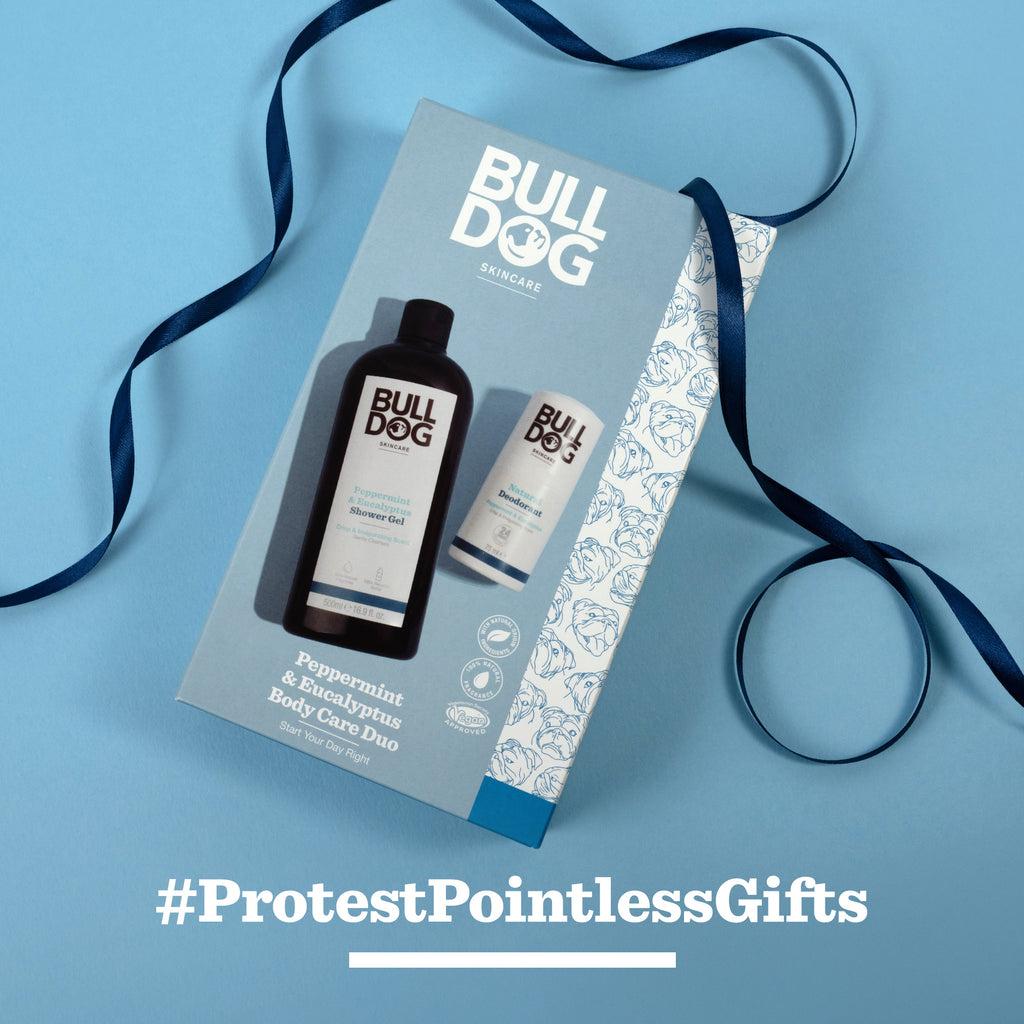 A Peppermint & Eucalyptus Body Care Duo with shower gel and sensitive moisturiser is displayed on a blue background with a blue ribbon. #ProtestPointlessGifts in white underneath—perfect for men who care.