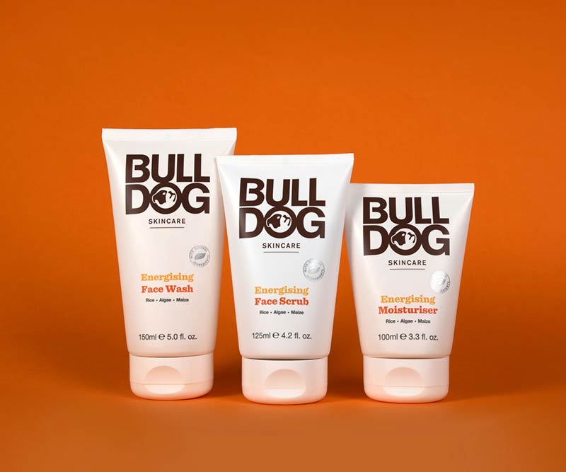 The Bulldog Energising Collection Bundle, featuring signature white packaging, is displayed upright on an orange background—perfect for enhancing your Energising Skincare or Bulldog Washbag routine.
